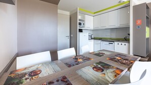 A modern kitchen with white cabinets, a microwave, and a coffee machine. - Courlis Cendré - Two Bedroom House, Sleeps 7 (Courseulles-sur-Mer)