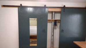 A room with a sliding wardrobe, a bed with patterned bedding, and a wooden table. - Very quiet ground floor basement apartment in the country, big outdoor space,!!! (THAYNE, WY)