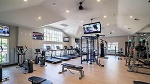 Ein großzügiger Fitnessraum mit Laufbändern, einer Bank und verschiedenen Trainingsgeräten.