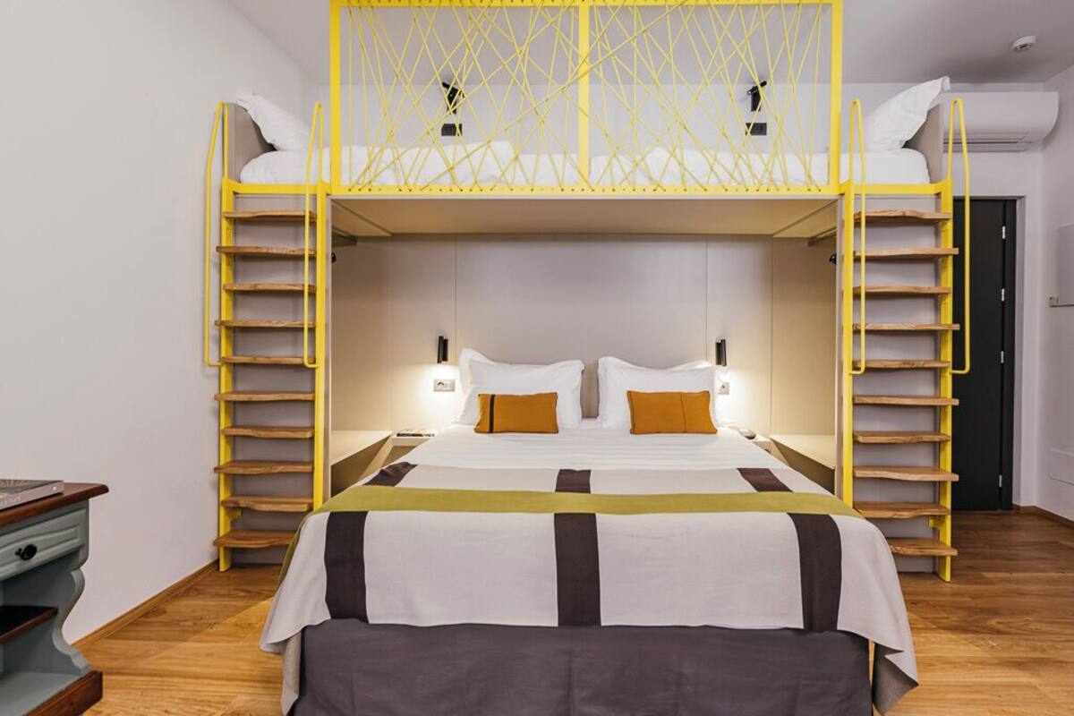 A room with a bunk bed, a desk, and a chair.