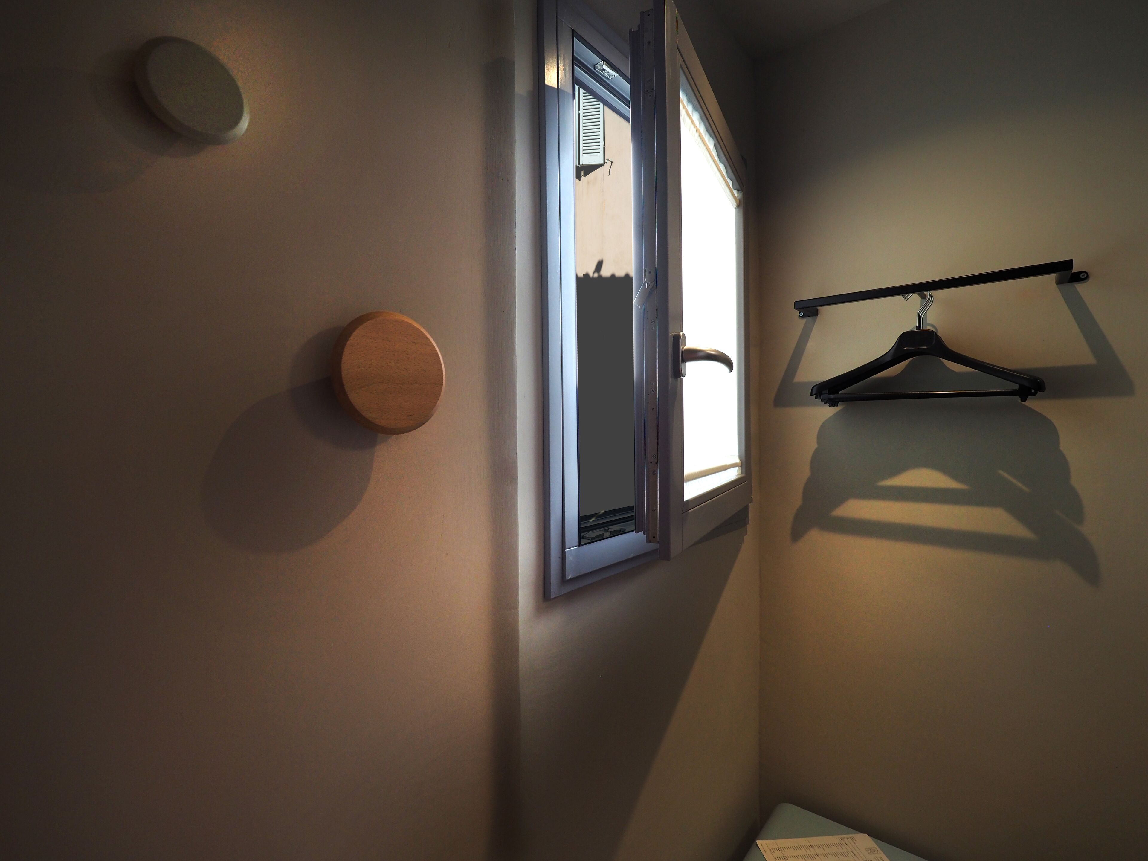 A room with a door, a window, and a coat rack.