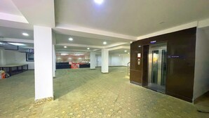 A spacious lobby with a patterned floor, a reception desk, and a reception area.