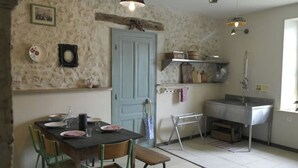 A kitchen with a dining table, chairs, a sink, and a door. - Vintage Touch (Hannonville-sous-les-Côtes)