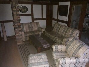 A living room with a sofa set, a coffee table, and a patterned rug.