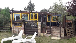 Un edificio rústico de madera con ventanas de marco amarillo y fachada de ladrillo.