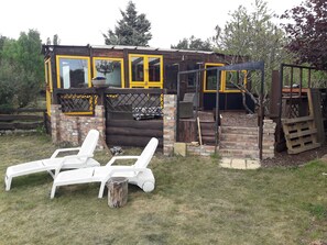 A rustic wooden building with yellow-framed windows and a brick exterior.