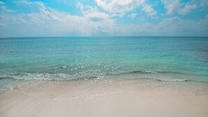 Una playa con agua turquesa cristalina y una orilla arenosa.