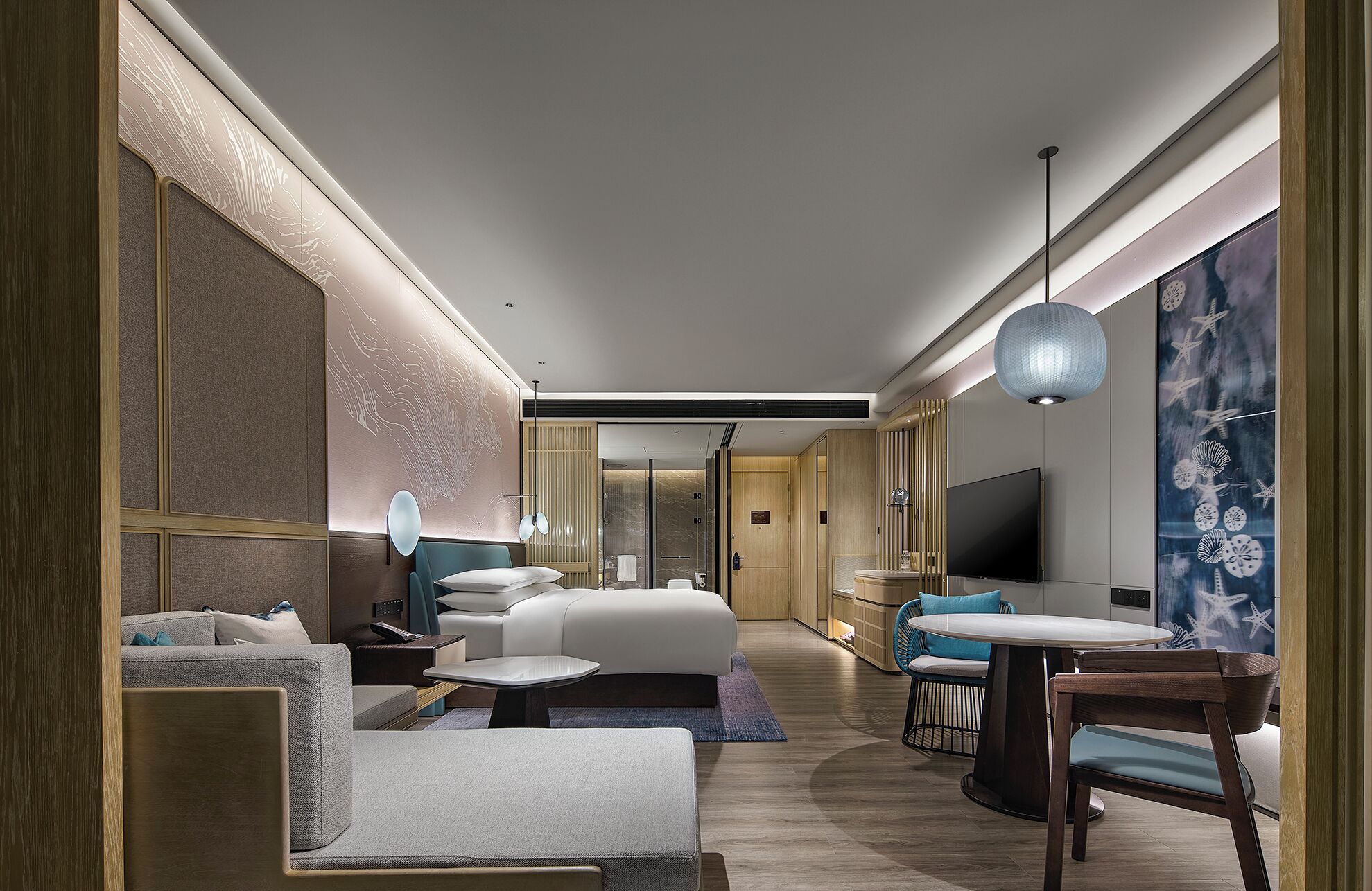Une chambre d’hôtel moderne dotée d’un grand lit, d’un coin salon avec une table et d’une télévision.