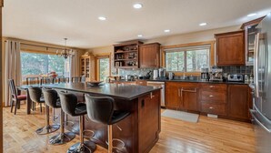 A spacious kitchen with a large island, wooden cabinets, and modern appliances. - 3 Bears Cabin | Games Room | Firepit | Lux Kitchen (Invermere)
