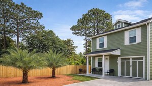 A two-story house with a covered patio, a fenced backyard, and a palm tree. - Cozy Coastal Home, 2 Mi to Navarre Beach (Navarre)