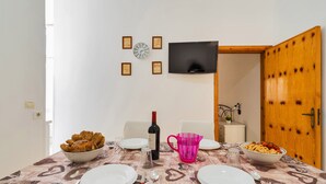A dining table set with plates, cutlery, a wine bottle, and bowls of food.