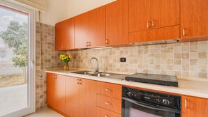 Una cucina moderna con mobili in legno, forno a incasso e lavello.