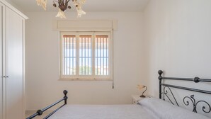 Una camera da letto con un letto, una finestra e un comodino.