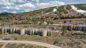 A residential area with modern houses, a winding road, and a mountainous backdrop.