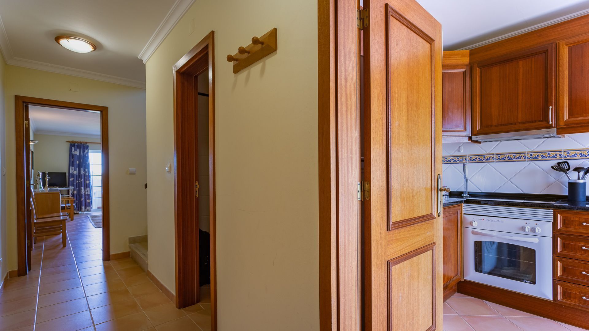 A kitchen with wooden cabinets, a stove, and a tiled backsplash.