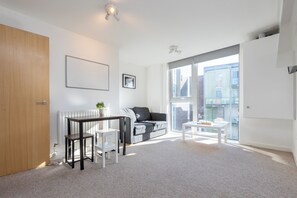Enjoy the city view from the large window in this stylish living room, featuring a comfortable sofa and a small table.
