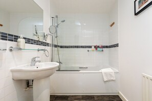 A bathroom with a sink, a glass shower enclosure, and a bathtub. - Bright and Airy 1BD Flat in Trendy Peckham (London)