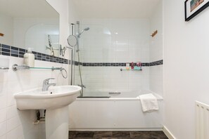 Enjoy a refreshing shower or soak in the bathtub, with a standalone sink and mirror nearby.