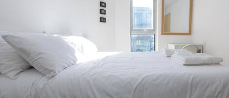 1 habitación, escritorio y tabla de planchar con plancha