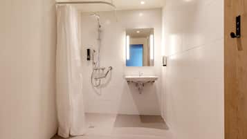 Un baño moderno con ducha, lavabo y espejo.
