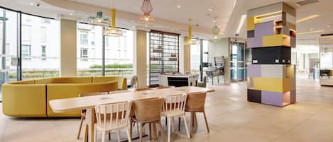 A modern dining area with a yellow sofa, wooden table, and chairs.
