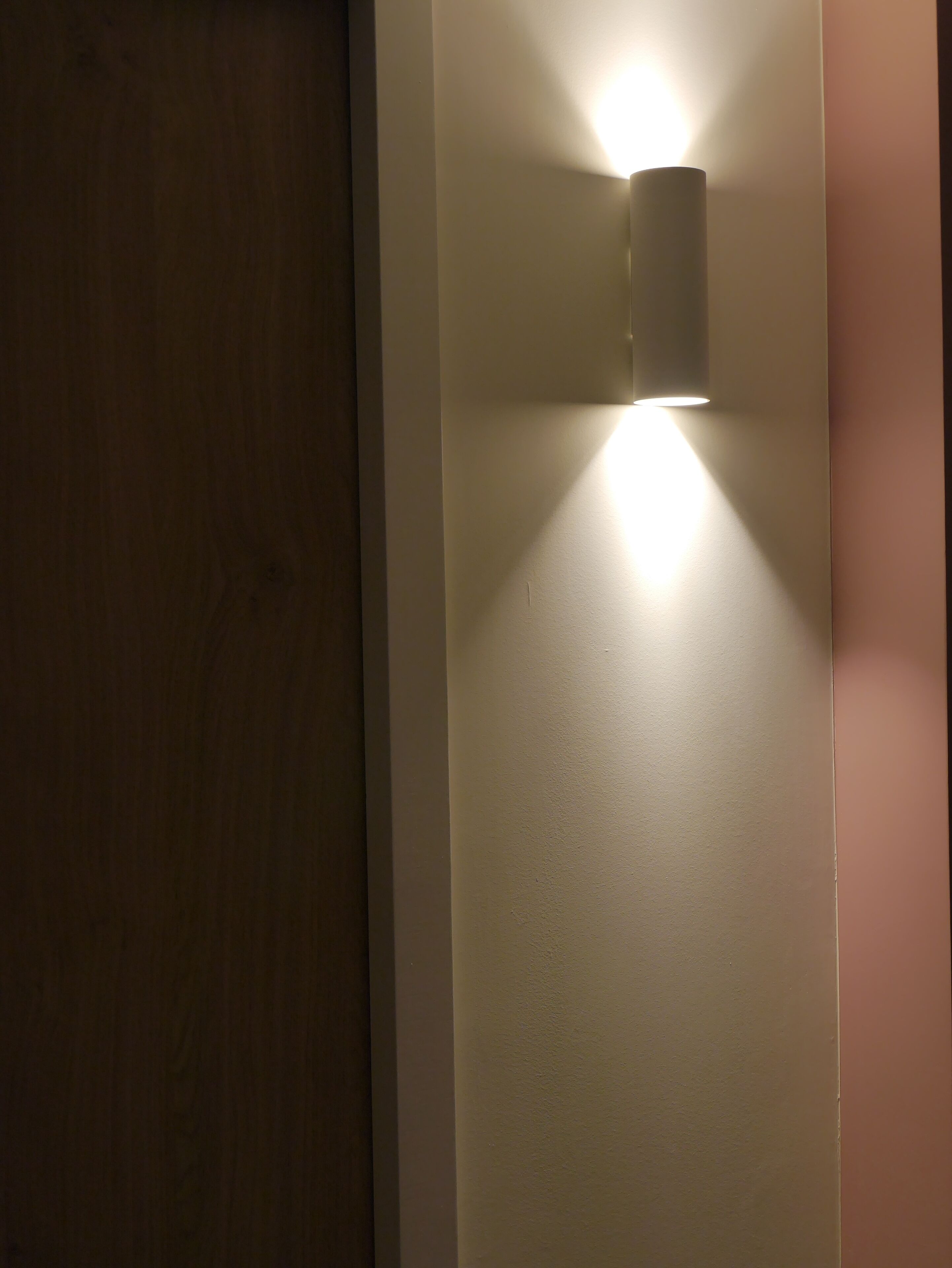 Un luminaire fixé au mur sur un mur uni.