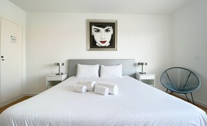 A hotel room with a large bed, two bedside tables with lamps, a chair, and a framed artwork on the wall. - Penthouse Triplex com Jacuzzi |T3 HsRentals Vilama (Vilamoura)