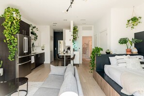 Un apartamento moderno con cocina, comedor y sala de estar con sofá y cama.