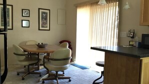 A dining area with a wooden table and chairs, a kitchen counter, and framed pictures on the wall. - Polaris Paradise Maverick, Entire townhouse in scenic Polaris, MT (Polaris)