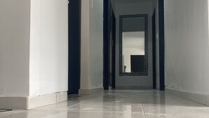 A corridor with a tiled floor and a recessed ceiling light. - Comfortable (La Romana)