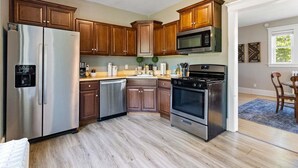 A kitchen with wooden cabinets, stainless steel appliances, and a window.