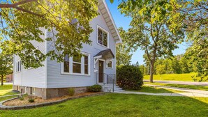A two-story house with a front porch, a small front yard, and a street view.