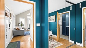 A modern interior with teal walls, a grey sofa, and a wooden floor. - Scandinavian Condo | Dragestil 723-3 (Duluth)