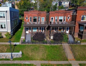A residential building with a central entrance, a covered porch, and a small garden area.