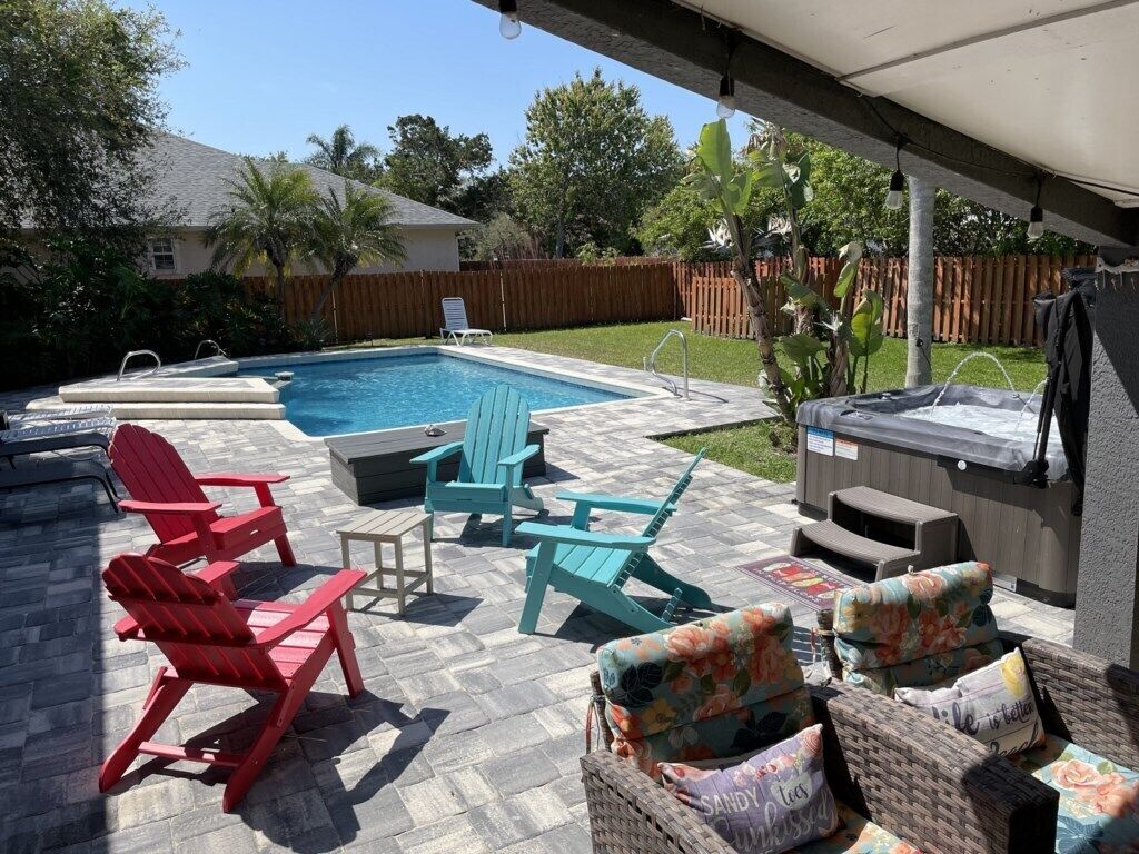 Ein Garten mit Swimmingpool, Sitzgelegenheit im Freien und Whirlpool.