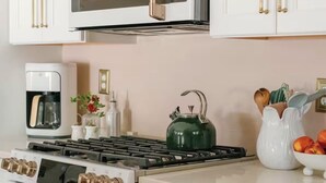 A kitchen with white cabinets, a microwave, a stove, and an oven.