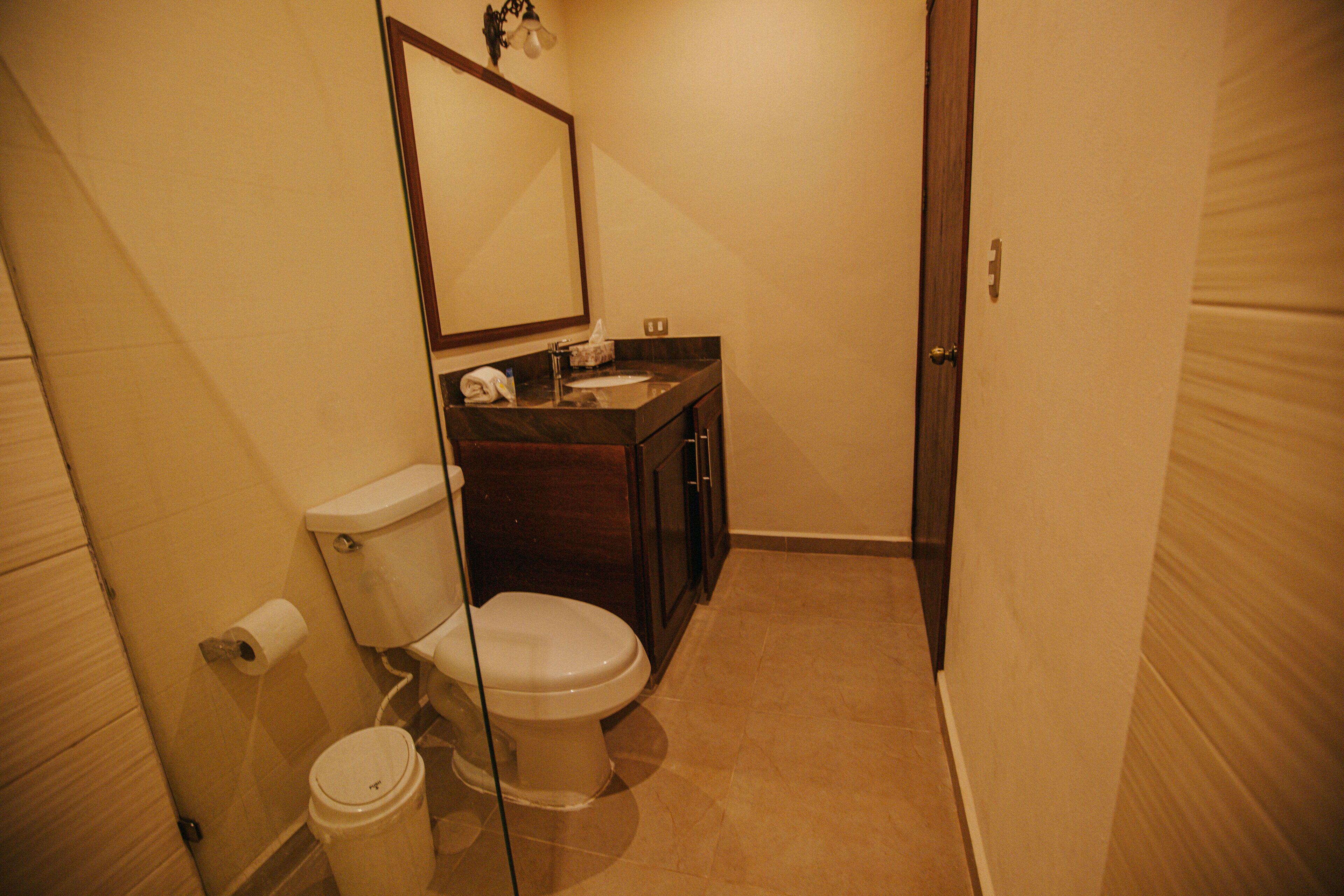 Un baño pequeño y funcional con inodoro, lavabo y espejo.