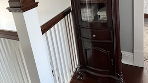 Un meuble en bois foncé, doté de portes en verre, renfermant des serviettes pliées avec soin.