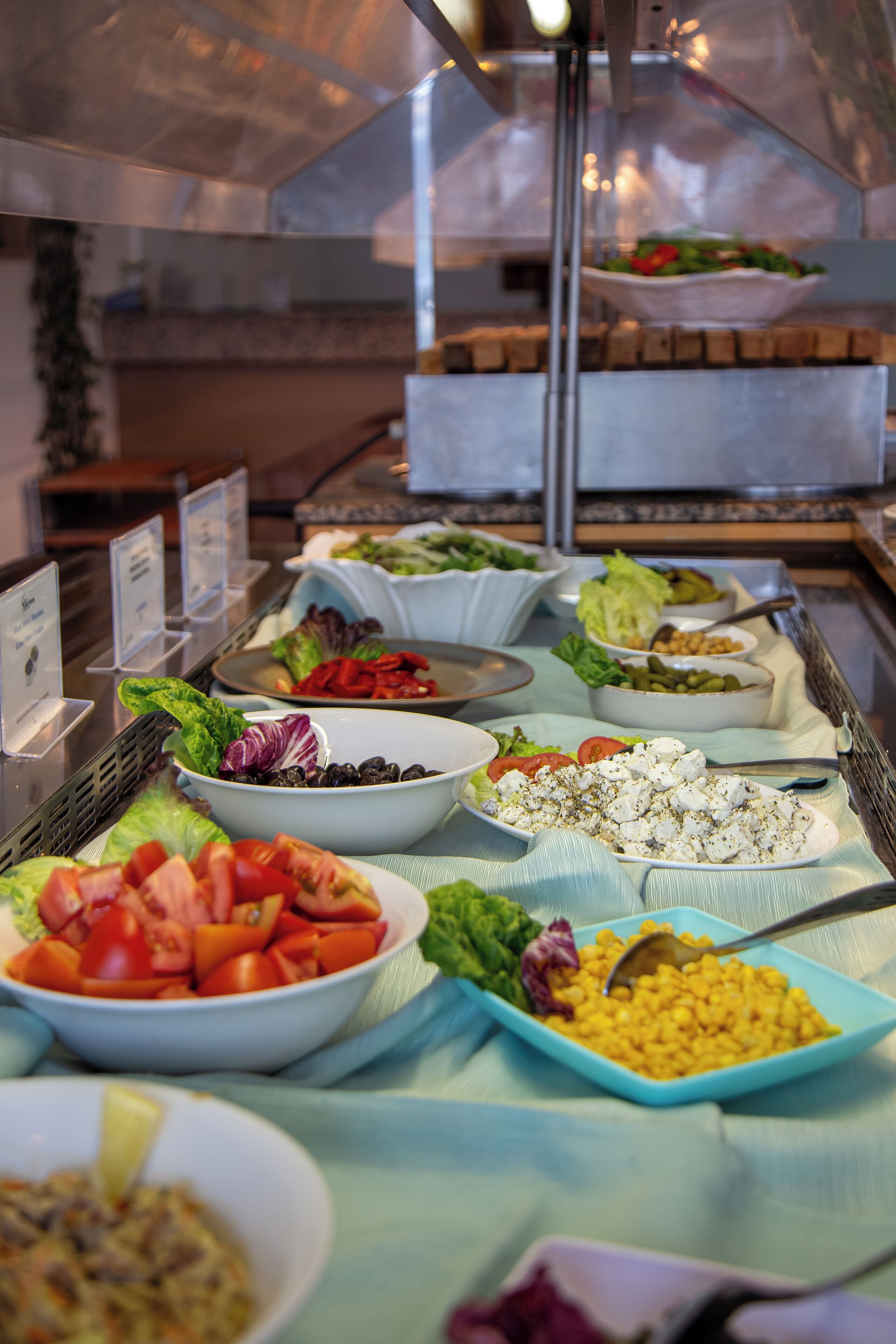 Un buffet proposant une variété de plats, notamment des salades, des fruits et des légumes.