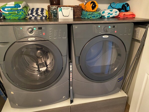 A front-loading Whirlpool washer and dryer unit with a control panel, placed on a countertop with folded laundry and a box of dryer sheets. - Desert Oasis with private pool<br>Policy # 110838 (La Quinta)
