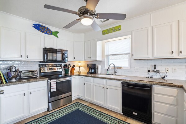 Enjoy cooking in this well-equipped kitchen with a range hood, microwave, and dishwasher.