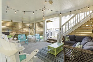 Relax in this charming outdoor seating area with a wooden deck, staircase, and cozy seating options.