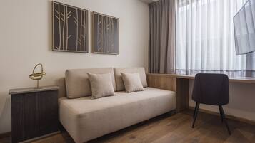 Een moderne woonkamer met een bank, een bijzettafeltje, een stoel en kunst aan de muur.