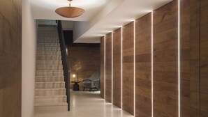 A modern interior with a staircase, wooden panel walls, and a pendant light. - Leonora Boutique Stays by Viadora (Mexico City)