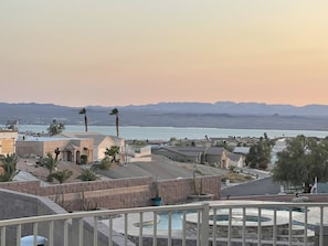 A residential area with a pool, houses, and a view of mountains and a body of water.