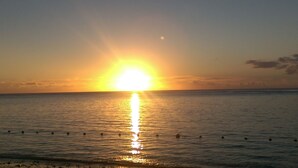 A sunset over a calm sea with a clear horizon. - Private and Fully equipped and furnished Family House Facing the Beach (Flic en Flac)