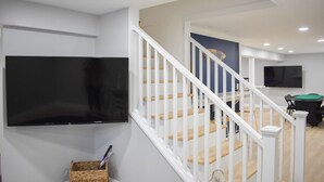 A modern interior with a staircase, a flat-screen TV, and a pool table. - Pristine condition! Three bedroom sleeping 8 with contemporary beach decor! (South Dennis)