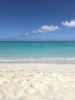 A beach with white sand and clear turquoise water.