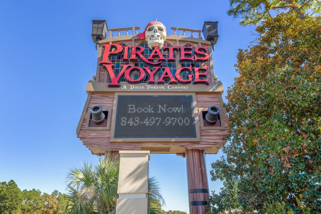 A sign for 'Pirates Voyage' with a booking number and phone number.