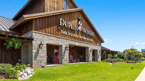 Un edificio de madera con un letrero que dice "DUPLIN WINERY THE WINERY OF THE SOUTH".